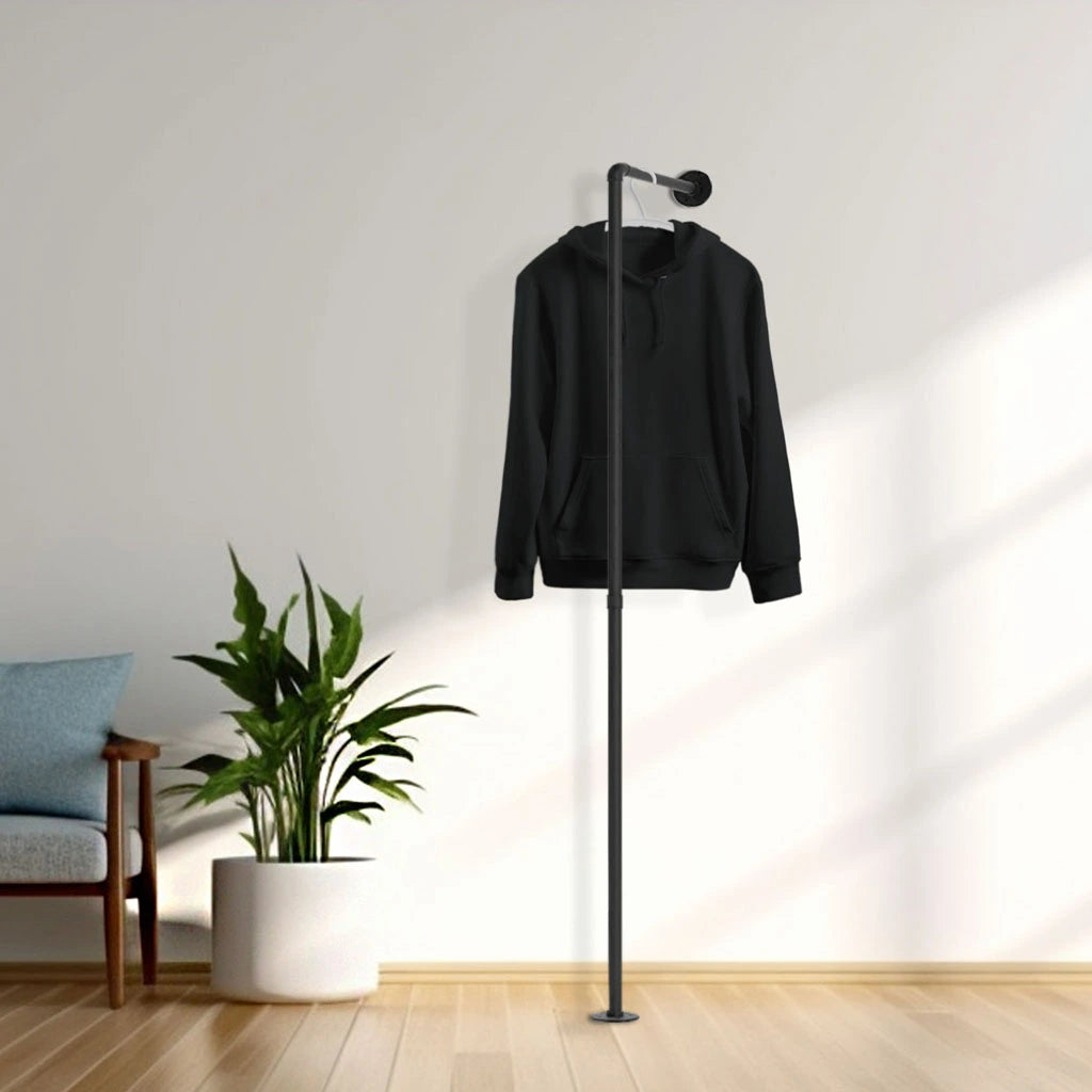 urb.style Otto Kleiderbügel aud Rohrstangen befestigt am Boden und an der Wand schwarze Stiefeln und hängender Hoodie links eine Topfpflanze